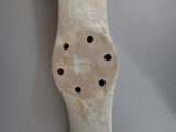 a wooden object with holes in the middle of it