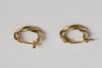 deux paires de boucles d'oreilles en or sur fond blanc
