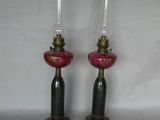 une paire de lampes en verre rose ornées de finitions dorées sur fond blanc