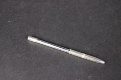 un stylo argenté posé sur une surface noire