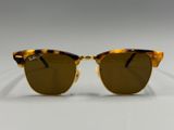 a pair of sunglasses with brown lenses on a white surface