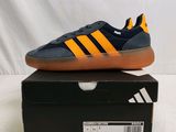 Les baskets adidas sont posées sur une boîte, sur une surface blanche.