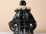 a black and white ceramic teapot with a woman ' s dress on it
