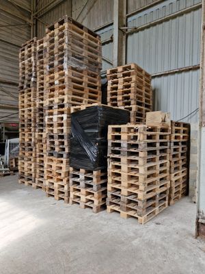 un gros tas de palettes dans un entrepôt