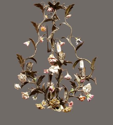 a chandelier with flowers and leaves hanging from it