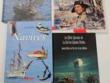 four books on a white table with a boat in the water