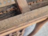 a close up of a wooden bench with holes in it