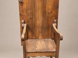 une vieille chaise en bois posée sur un parquet