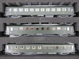 trois trains miniatures exposés dans une vitrine