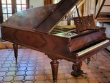 un piano à queue dans une pièce au sol carrelé