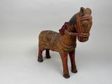 a small wooden horse with a harness on it ' s back