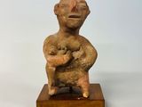 une petite statue représentant un homme tenant un bébé dans ses bras