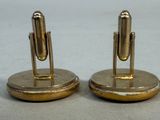 pair of brass plated bookends with a pen on top
