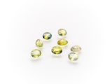a group of yellow and green tourmaline gems on a white background