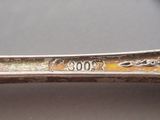a silver spoon with a design on it on a table