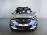 the front view of a silver car parked in a showroom