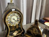 two clocks sitting on a table next to each other