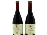 two bottles of red wine sitting next to each other on a white surface
