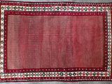 un tapis rouge à motifs posé sur un sol gris