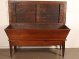 an old wooden bench with a metal top and a wooden seat