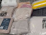 many bags of clothing sitting on a shopping cart