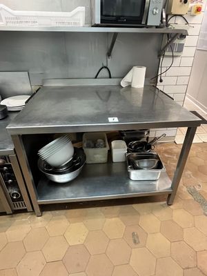 une cuisine équipée d'une table en inox et d'un micro-ondes