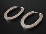 pair of silver hoop earrings on a black surface