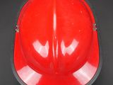 a red fireman ' s helmet on a black background