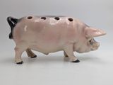 a pig figurine that is standing on a white surface