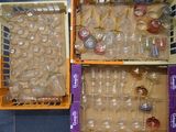 des cartons contenant des verres à vin vides, posés sur un sol carrelé