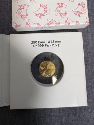 une pièce d'or dans une boîte blanche posée sur une table