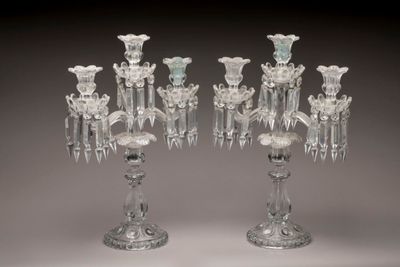 une paire de bougeoirs en verre transparent, ornés chacun de fleurs