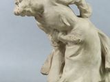 sculpture of a woman on a rock with a dog on her back