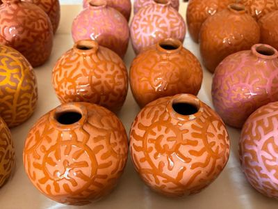 de nombreux vases de différentes couleurs posés sur une table