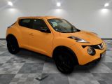 the orange nissan juke suv is parked on a checkered floor