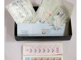 une boîte noire contenant des timbres et des enveloppes