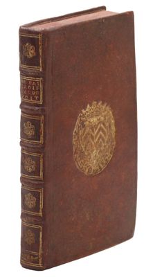un vieux livre orné d'un emblème doré sur la couverture