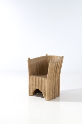 une chaise en osier posée sur une surface blanche