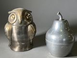 un vase en argent et une figurine de chouette posés l'un à côté de l'autre