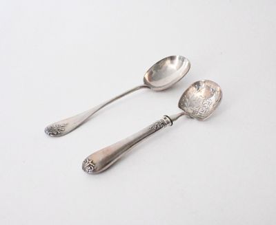 two spoons and a spoon rest on a white surface