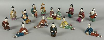 many figurines of asian people sitting in a circle
