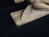 a statue of a woman sitting on top of a book