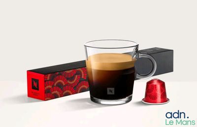 une tasse de café à côté d'une boîte de dosettes de café