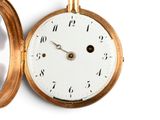 a gold pocket watch with a white face and numbers on it