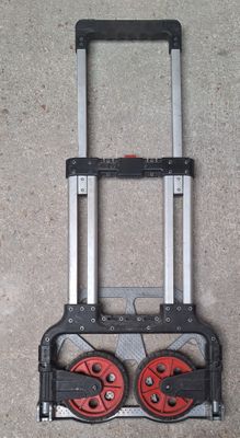a hand truck with two red wheels on the floor