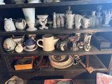 une étagère sur laquelle sont disposés de nombreux vases de toutes sortes