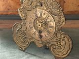 une horloge posée par terre à côté d'une commode
