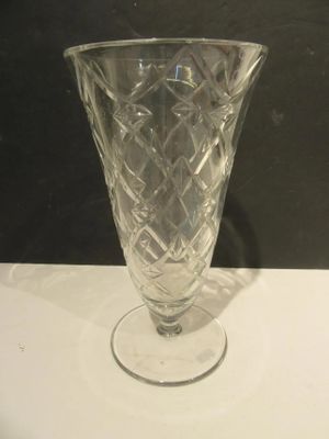 un vase en verre posé sur une table, sur fond noir