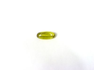 un gros plan d'une pierre jaune de forme ovale posée sur une surface blanche