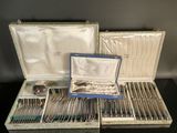 an assortment of silverware in a case on a table
